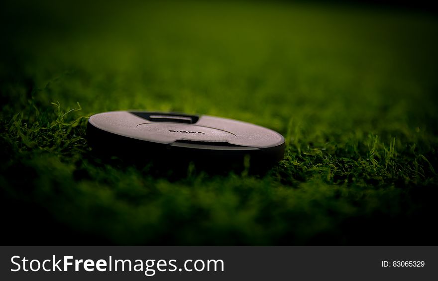 Black Camera Lens Cover On Green Grass