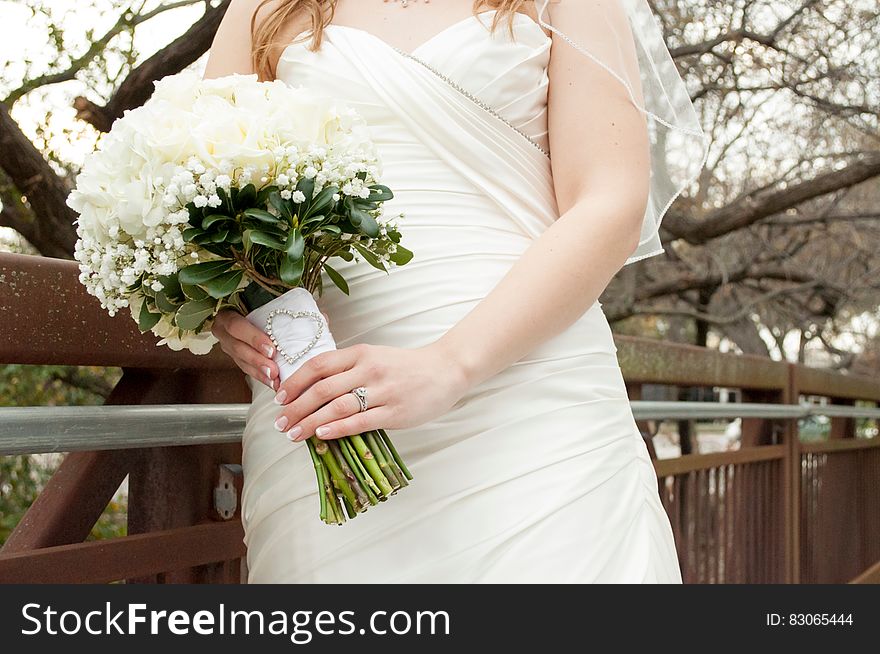 A bride dressed in white gown with a white bouquet. A bride dressed in white gown with a white bouquet.
