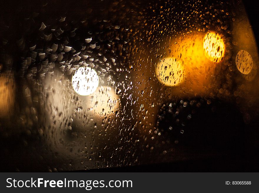 Raindrops and light reflecting on window