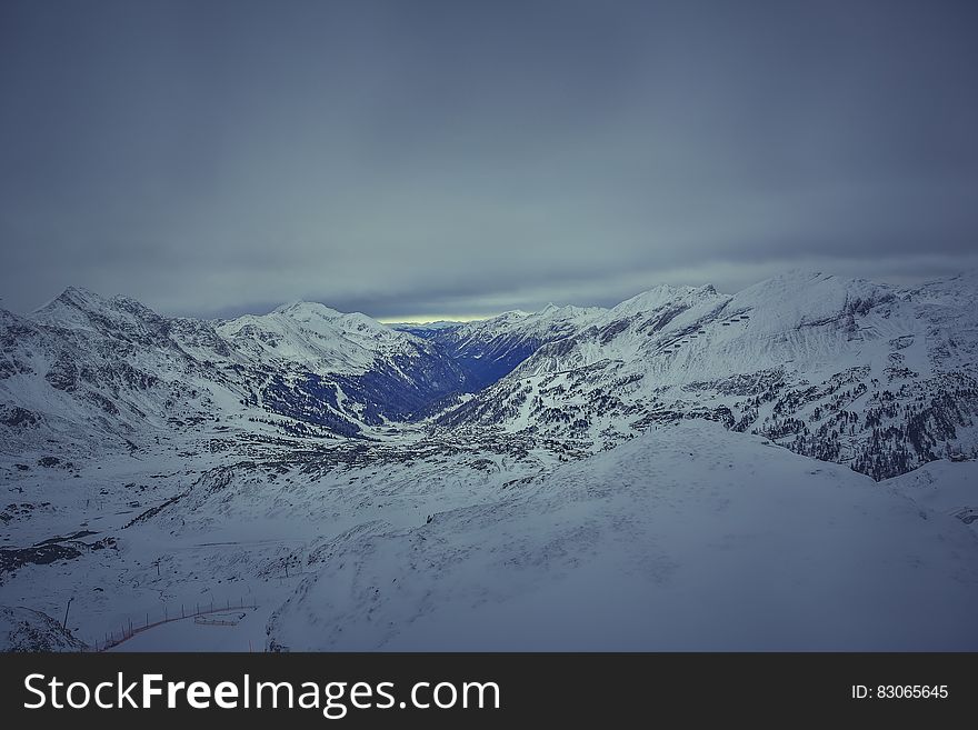 Mountain Covered in Snow Under White Cloudy Sky during Daytime