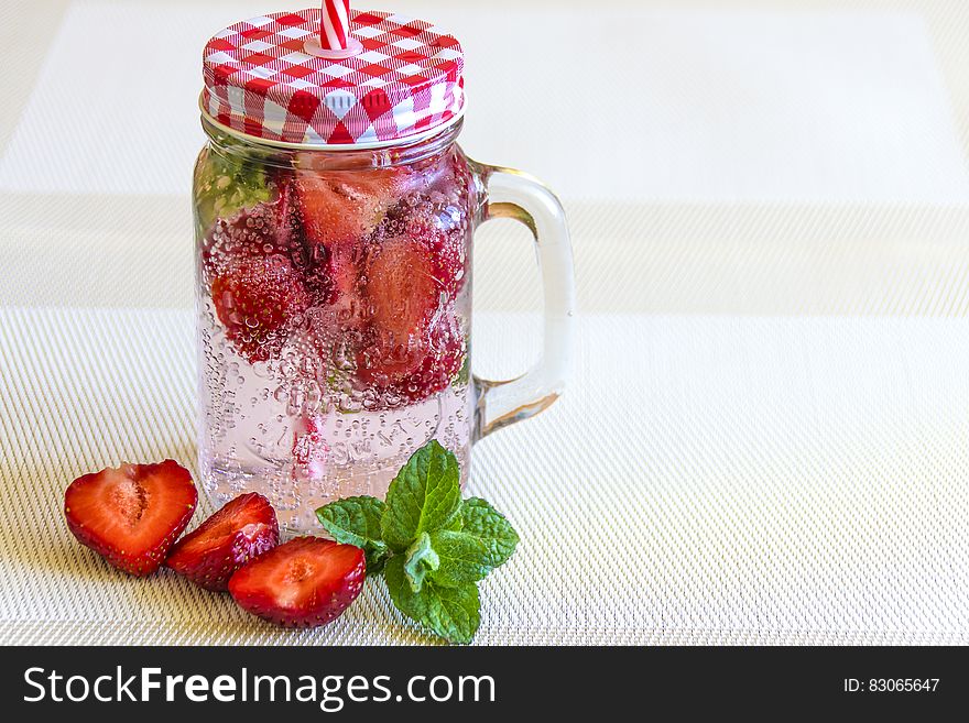 Strawberry Fruits Sliced in Half Near Clear Glass Container