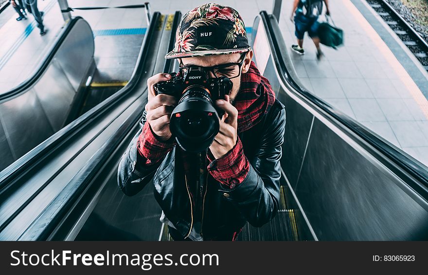 Man Wearing Black Leather Zip Up Jacket and Dslr Camera