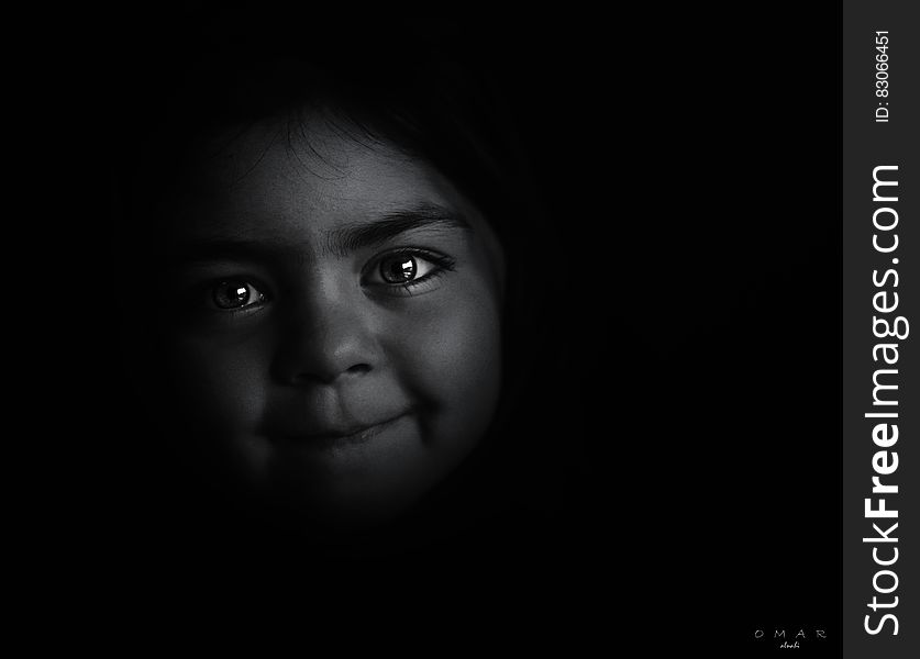 Studio portrait of face of young girl in shadows in black and white. Studio portrait of face of young girl in shadows in black and white.