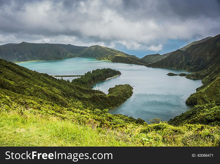 Blue Lake Behind Green Mountain Under White Clouds