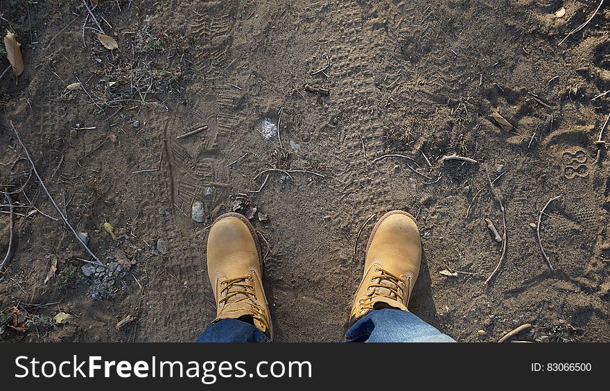 Overhead view of leather hiking boots on dirt ground. Overhead view of leather hiking boots on dirt ground.