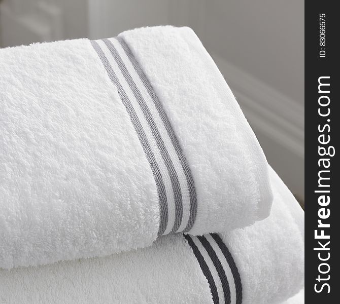 Close up of white terry cloth towels in bathroom.