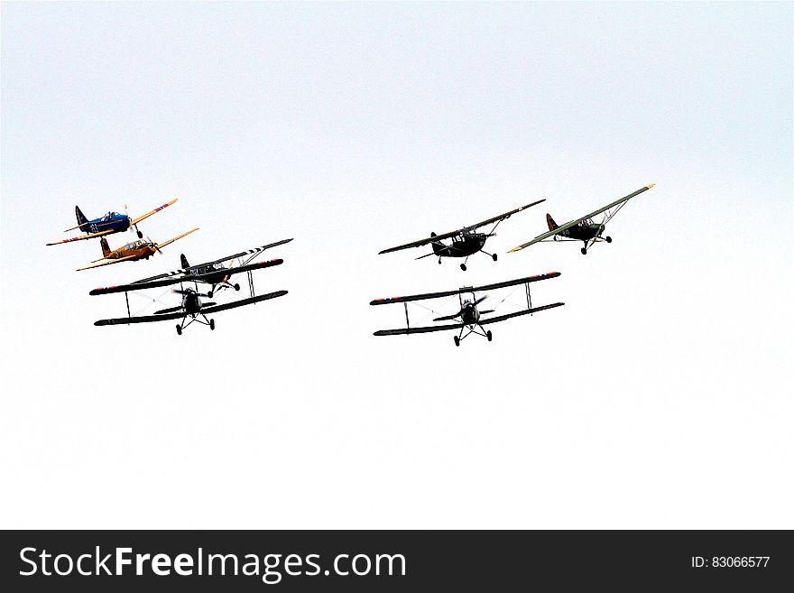 7 Biplane Flying on Air Under Clouds during Daytime
