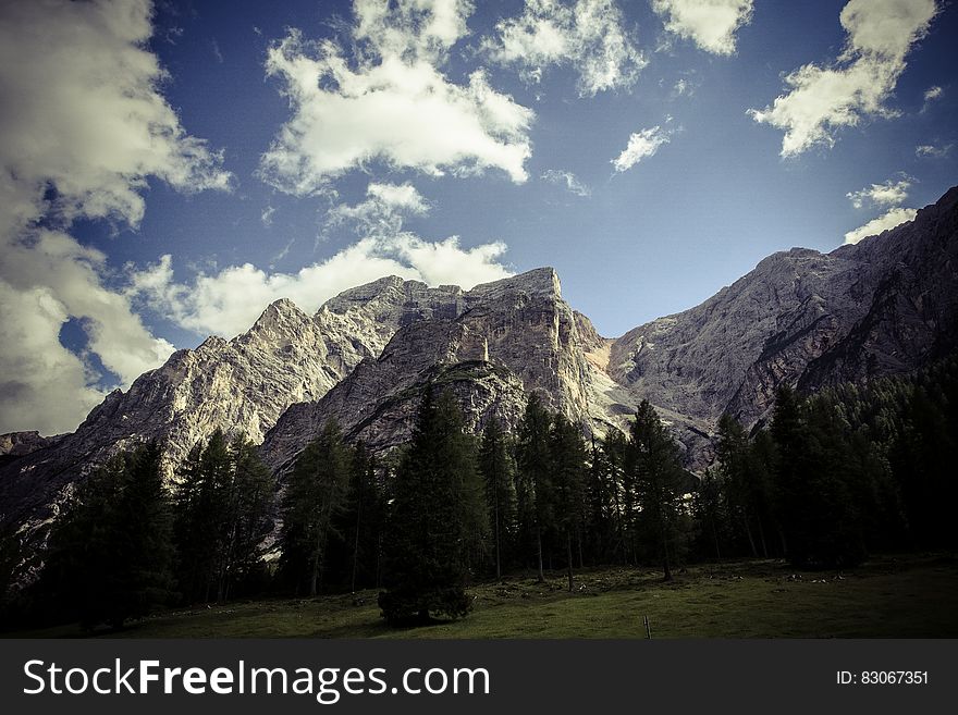 Rocky mountain peaks in landscape against blue skies on sunny day.