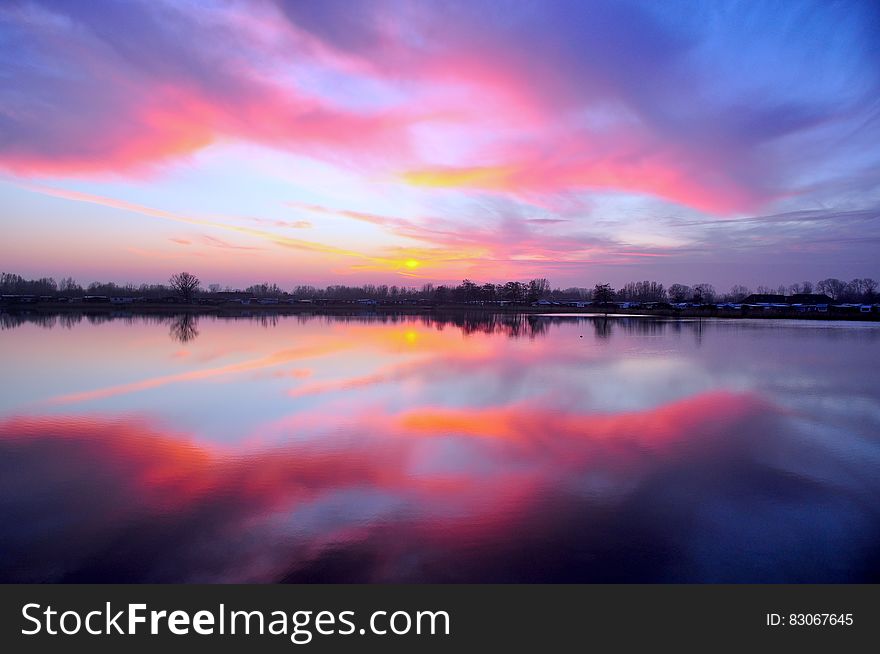 The colorful sunset sky reflecting on the water of a lake. The colorful sunset sky reflecting on the water of a lake.