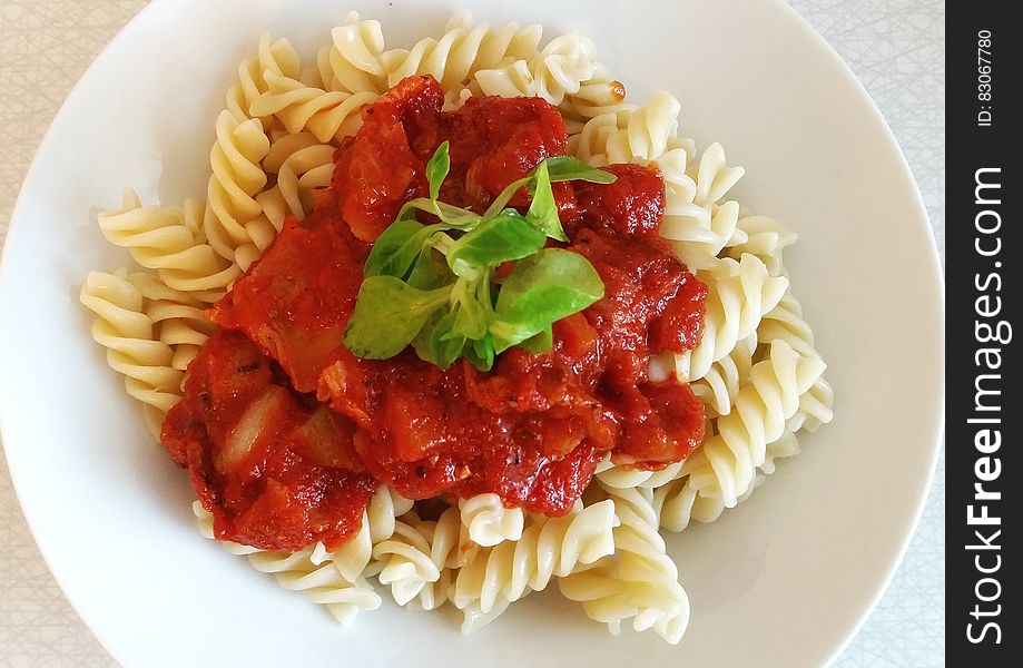 A close up of a portion of pasta with tomato sauce.