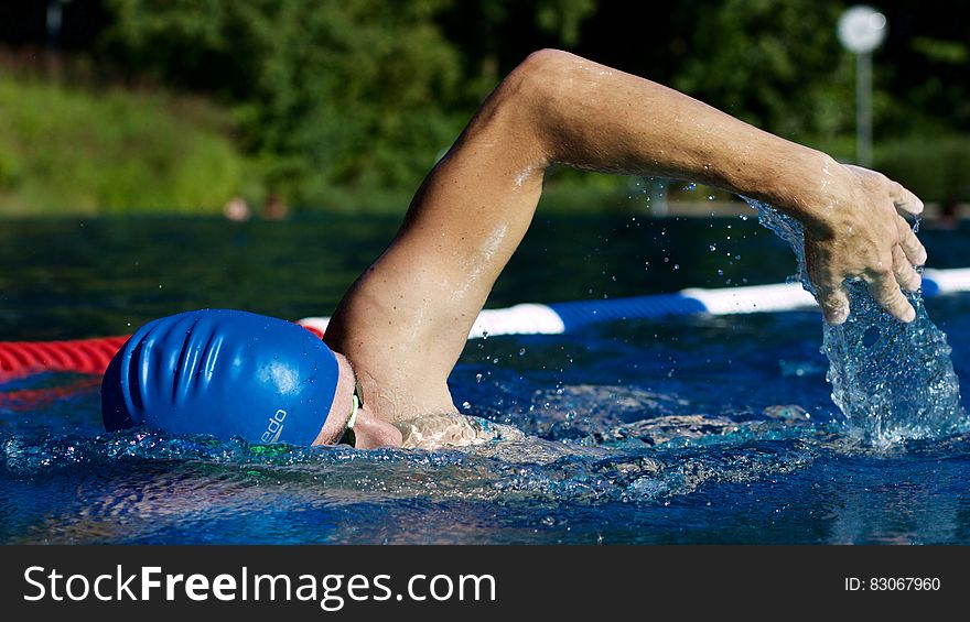 Man Swimming on Pool during Night Time