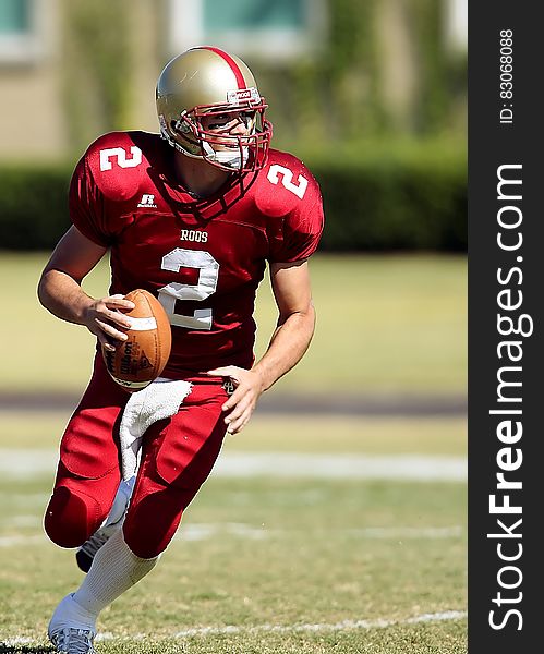 Football Player With Ball Running on Green Field during Daytime