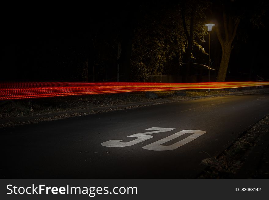 Time Lapse Photography of Red and Orange Light on Road With 30 Print on Nighttime