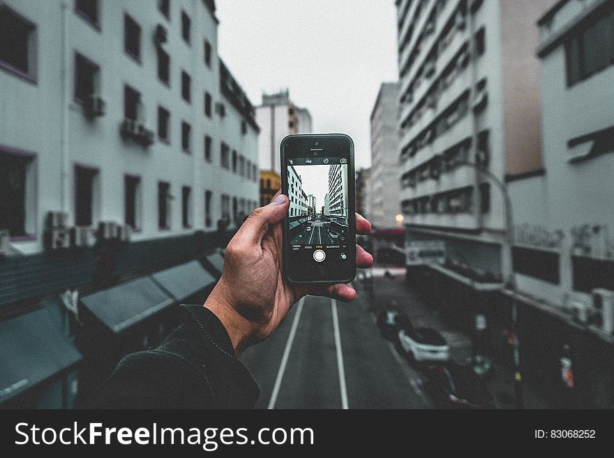 Man Holding Smartphone Capturing Roadway