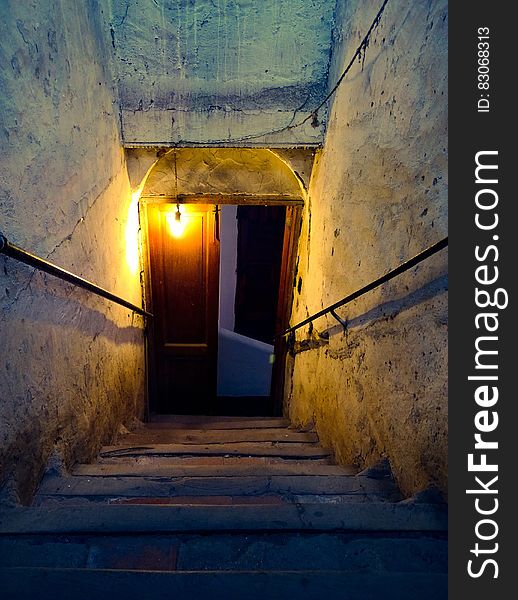 Brown Wooden Door Near Concrete Stairs With Light