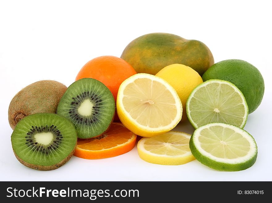 Fresh fruits, kiwis, lemons, limes and oranges on white background.