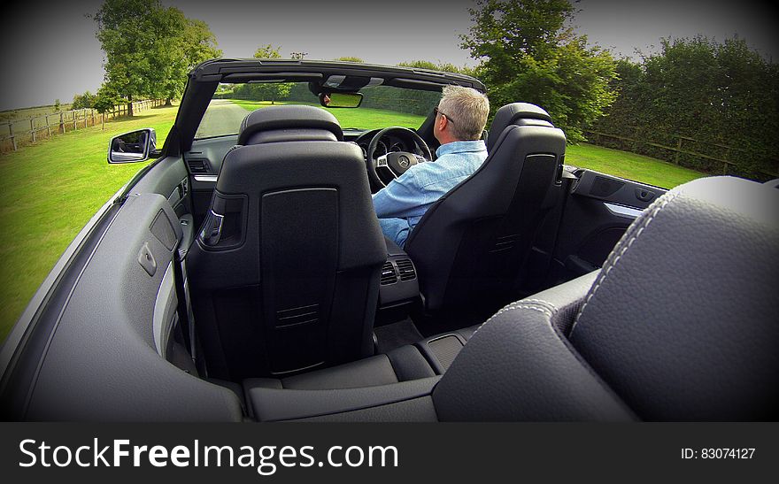 Man in Blue Dress Shirt Driving Convertible Car during Daytime