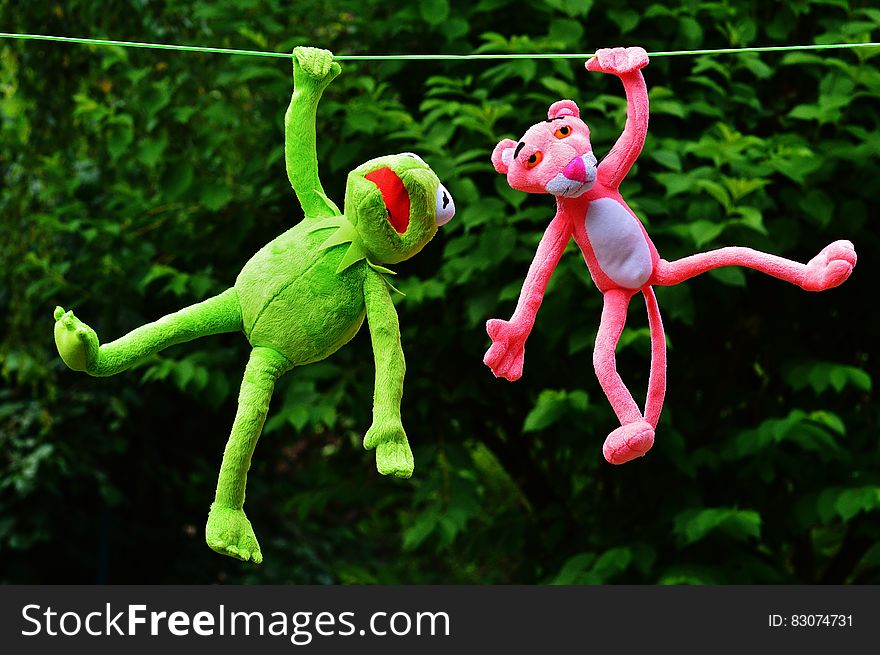 Shallow Focus Photography of Pink Panther and Kermit the Frog Plush Toy