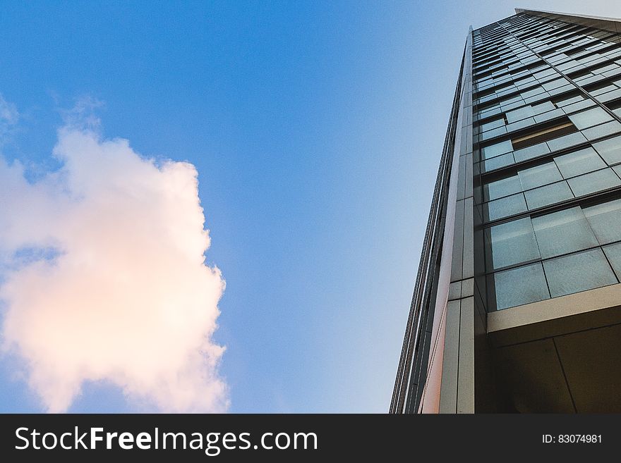 Facade of modern glass panel building against blue skies. Facade of modern glass panel building against blue skies.