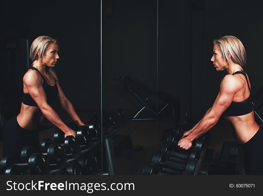 Athletic woman lifting free weights in gym. Athletic woman lifting free weights in gym.