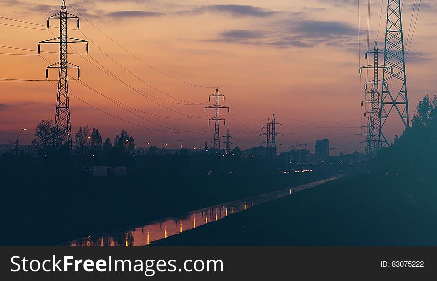 National grid power lines and pylons seen at sunset with a hint of atmospheric pollution close to edge of a city. National grid power lines and pylons seen at sunset with a hint of atmospheric pollution close to edge of a city.