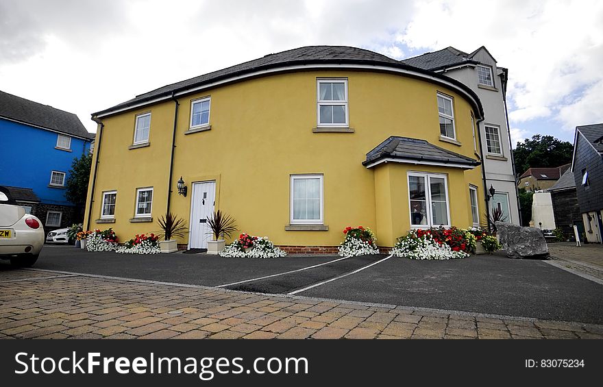 Exterior of bright yellow house in town.