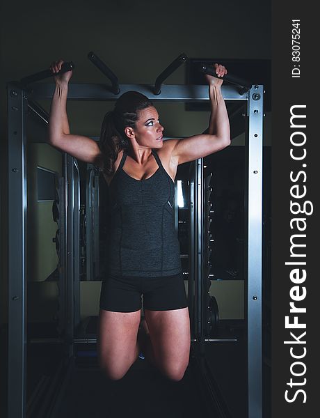 Muscular woman working out with fitness equipment in gym. Muscular woman working out with fitness equipment in gym.