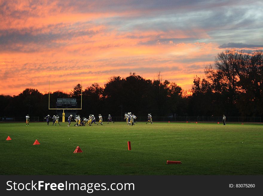 Football game on field with setting sun. Football game on field with setting sun.