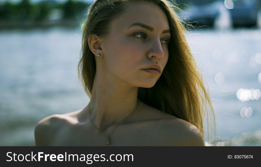 Closeup Photography of Woman With Gold Necklace Near Body of Water during Daytime