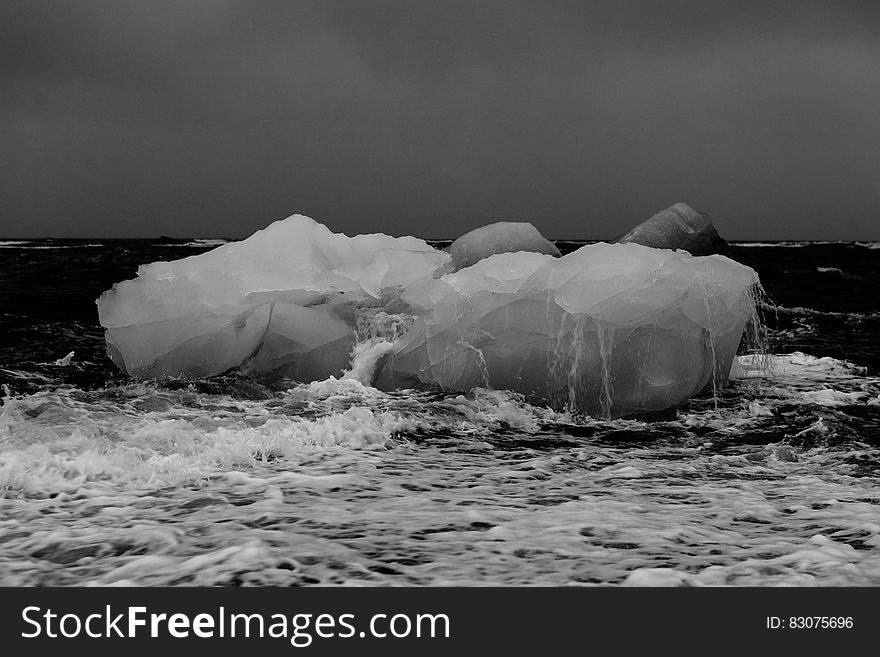 Icebergs on beach in black and white.