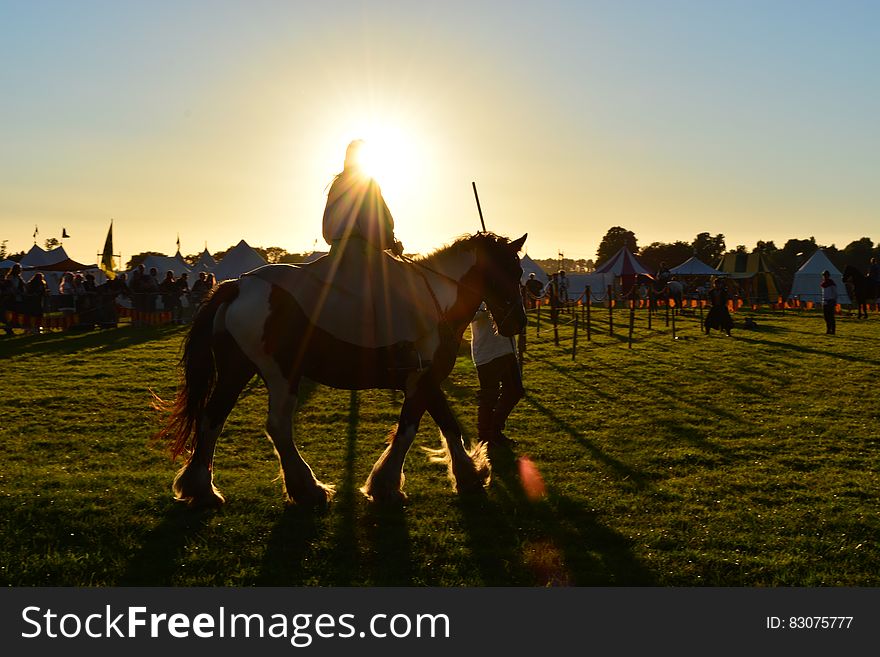 Person Riding on Horse Under Cloudy Sky during Daytime