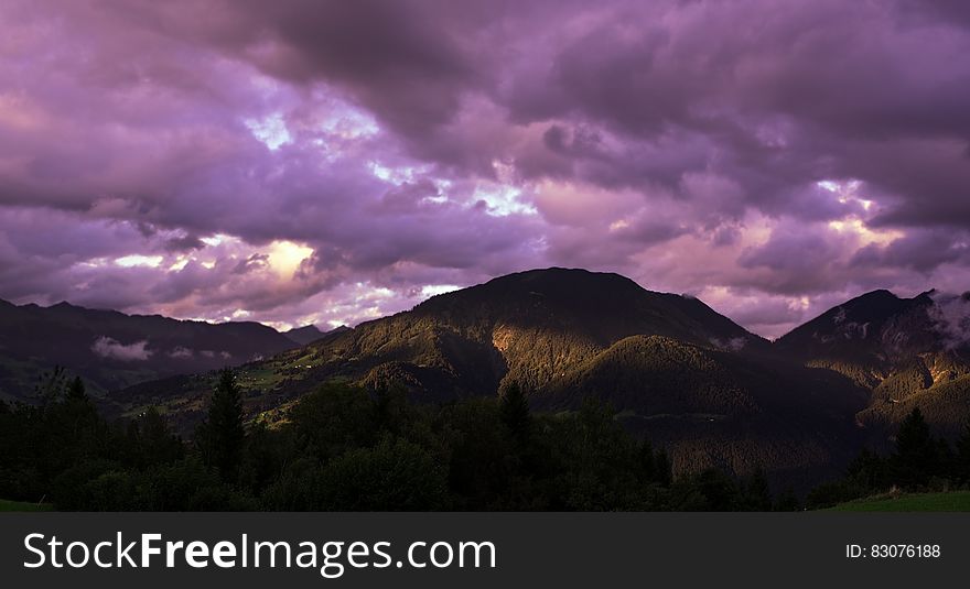 Brown Mountain Under Cloudy Sky during Sunset