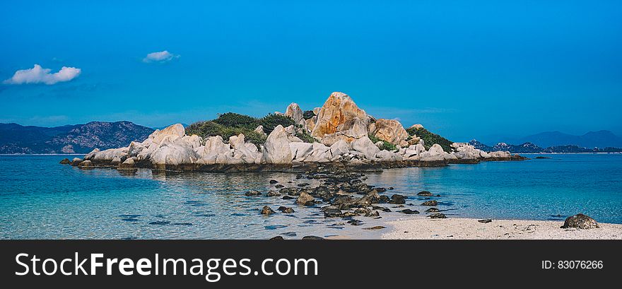 Rocky Island Surrounded By White Water