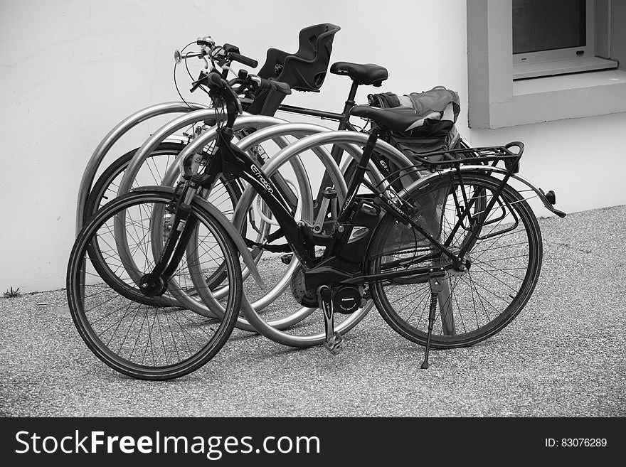 Black and Grey Bicycle Park Beside Wall