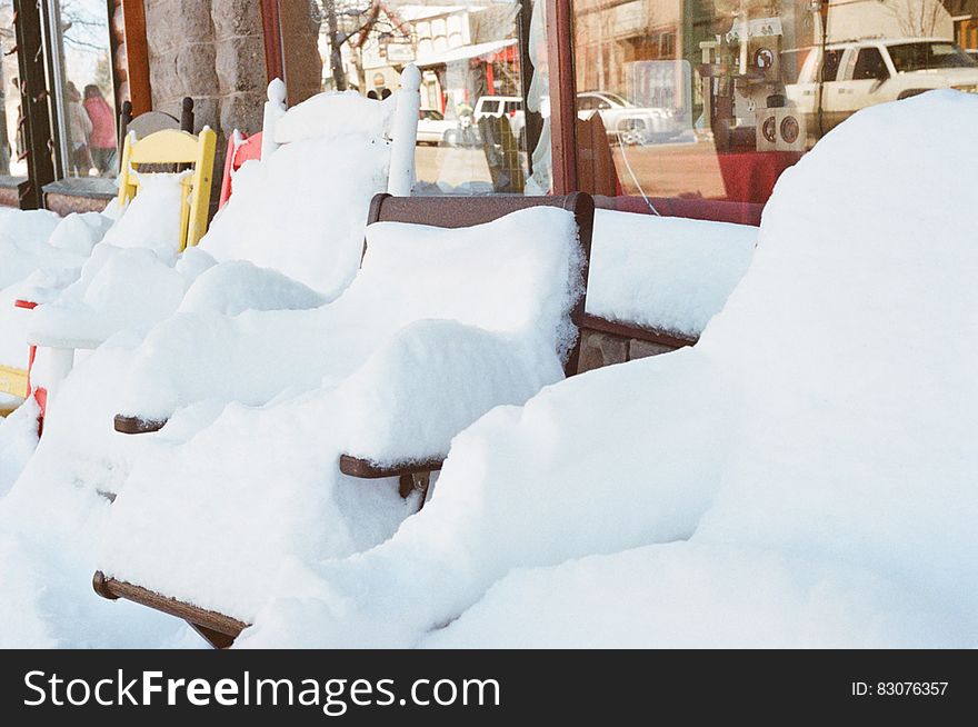 A row of chairs covered in snow.