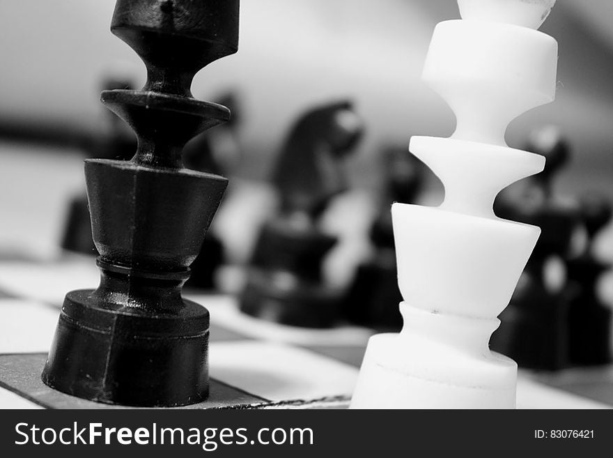 A black and white photo of pieces on chess board. A black and white photo of pieces on chess board.