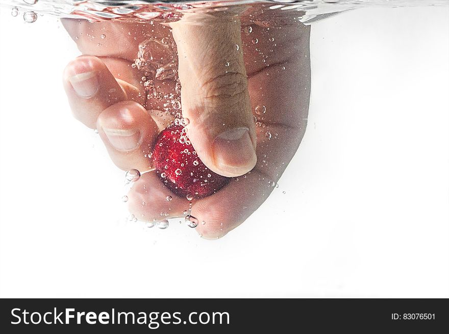 Person Holding Red Ball Underwater