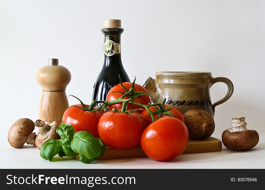 Mushrooms, basil, tomatoes and kitchen accessories on a white background. Mushrooms, basil, tomatoes and kitchen accessories on a white background.