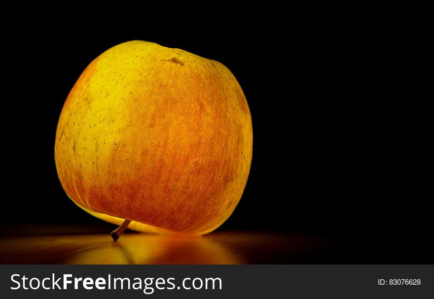 Lighted Apple over Black Surface