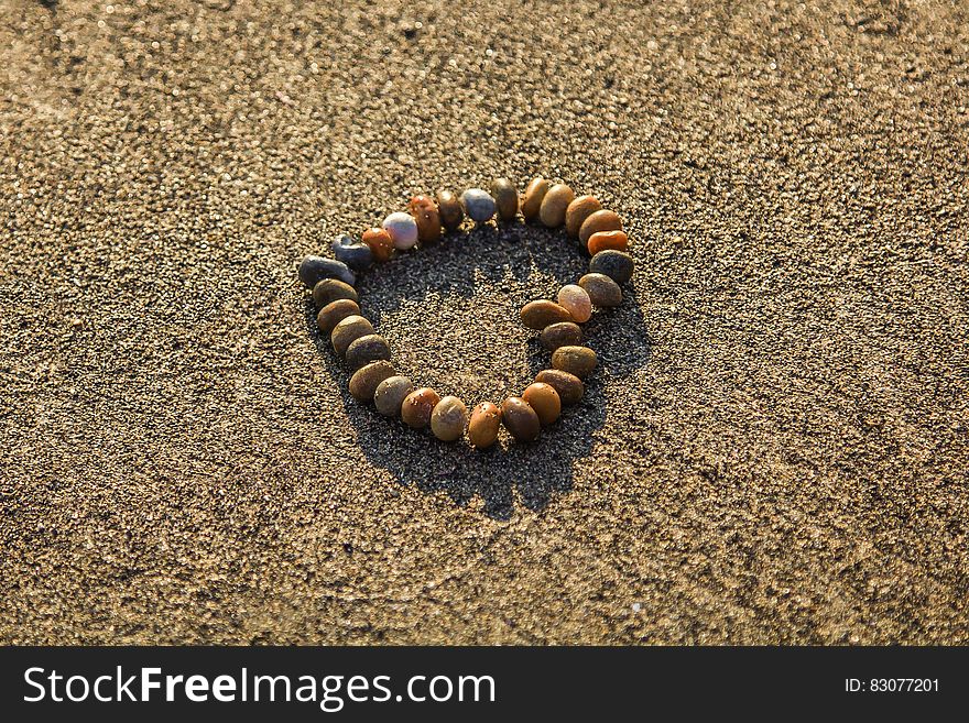 Brown and Grey Stone Formed Heart on Sand