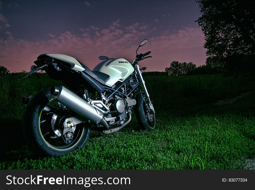 A motorbike resting on green grass. A motorbike resting on green grass.