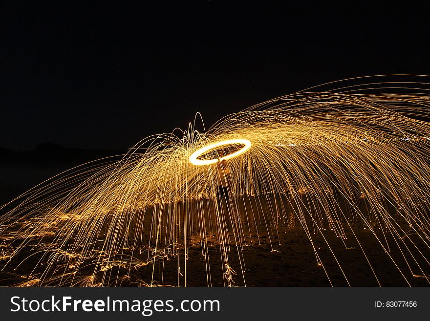 A long exposure of a burning fire ring with streaks caused by sparks.