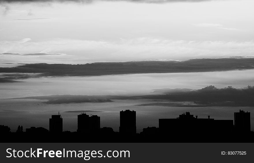 Silhouette Of Buildings Under Gray Clouds