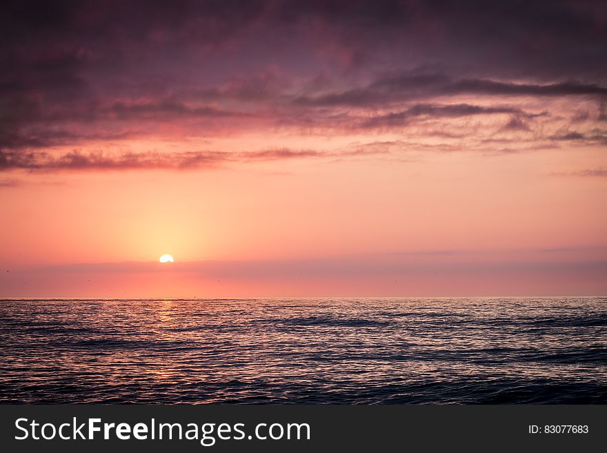 Sun setting over the horizon in open sea. Sun setting over the horizon in open sea.