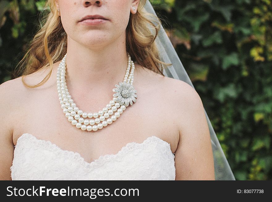 Woman in White Lace Strapless Sweetheart Bridal Gown White Bridal Veil and Pearl Beaded Necklace