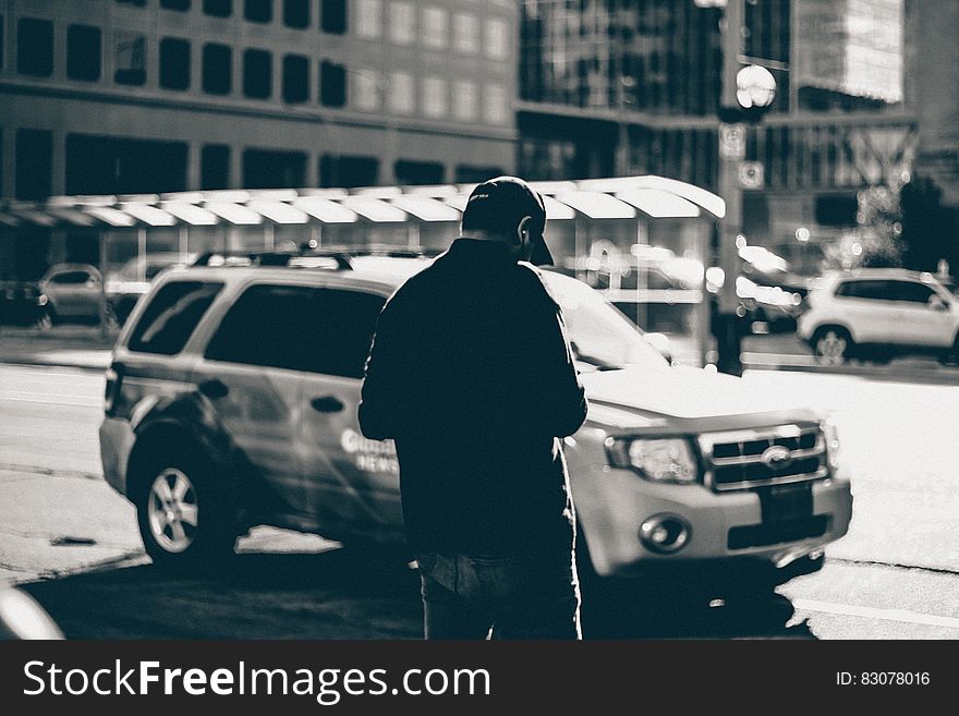 Grayscale Photography of Man Standing Near Suv during Daytime