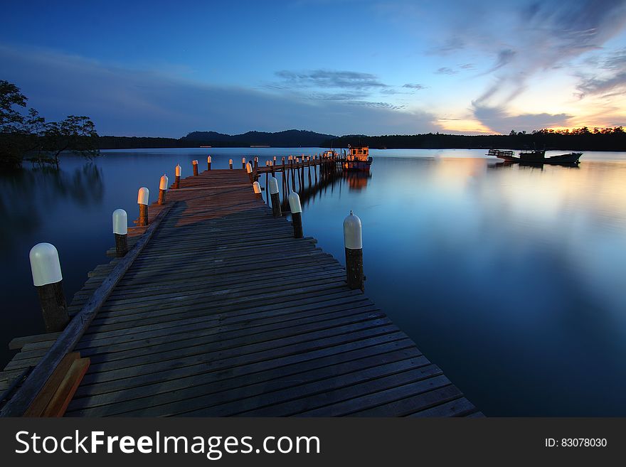 A wooden jetty in the water at sunset. A wooden jetty in the water at sunset.