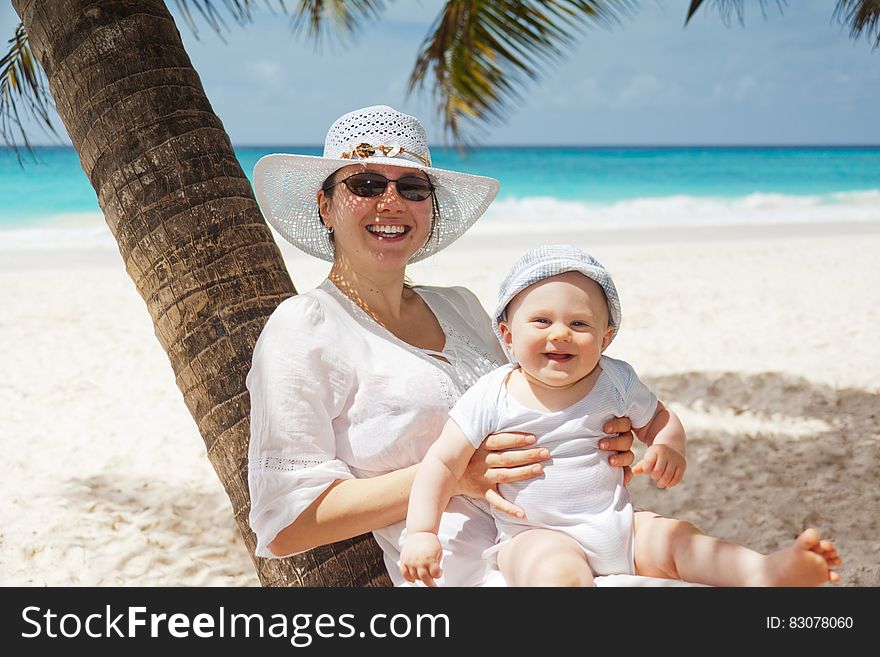 Woman Holding Infant on Beach
