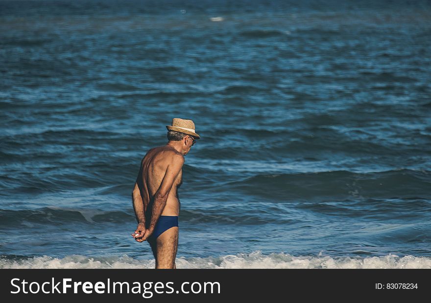 Elder man next to sea water on the beach. Elder man next to sea water on the beach