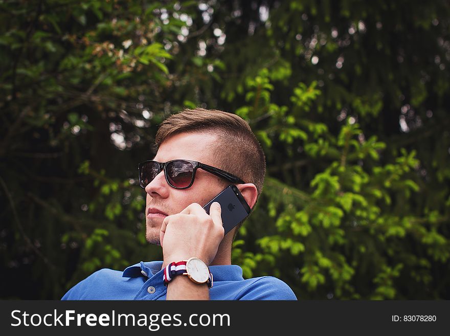 Young man talking on a mobile phone outdoors. Young man talking on a mobile phone outdoors.